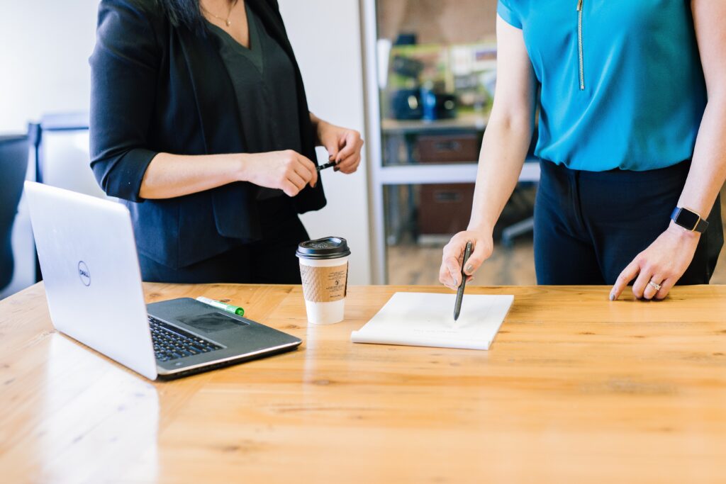 Two females pointing on a paper with all the business metrics they need to execute to achieve successful business transformation