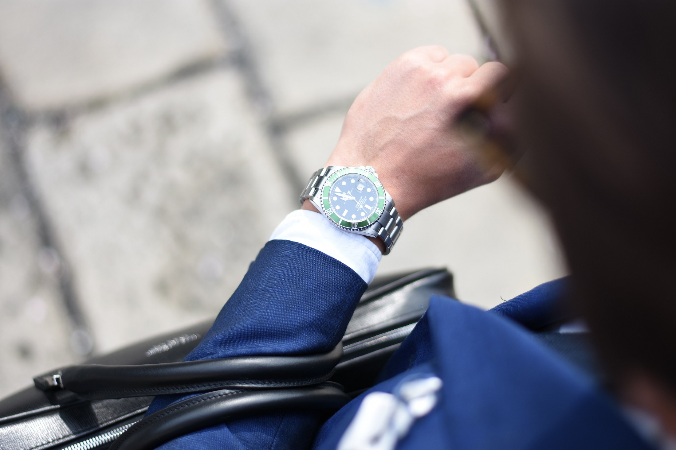 A businessman looking at his watch to catch an interview with his employer of choice