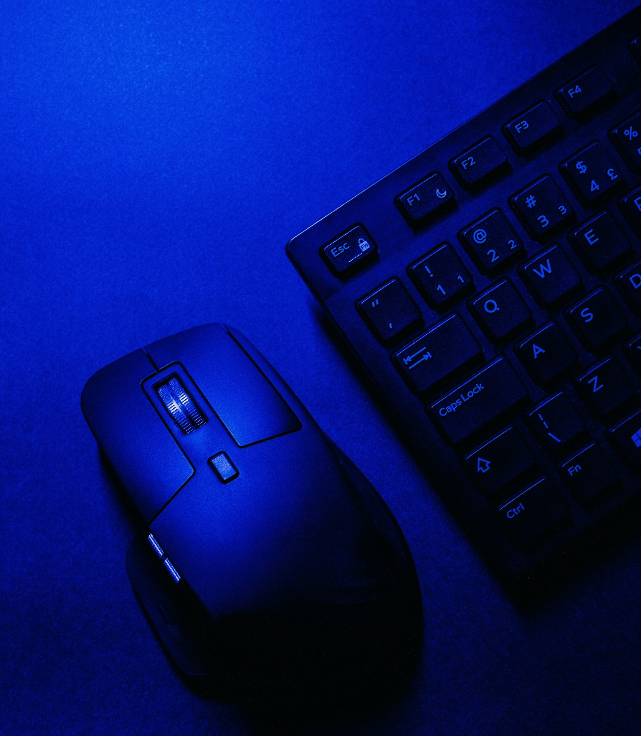 A mouse and keyboard with blue light representing change management for project managers and innovation